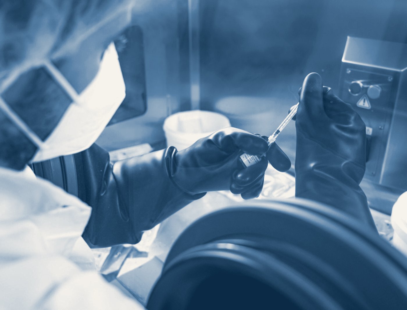 Un operatore lavora sotto cappa con guanti e mascherina